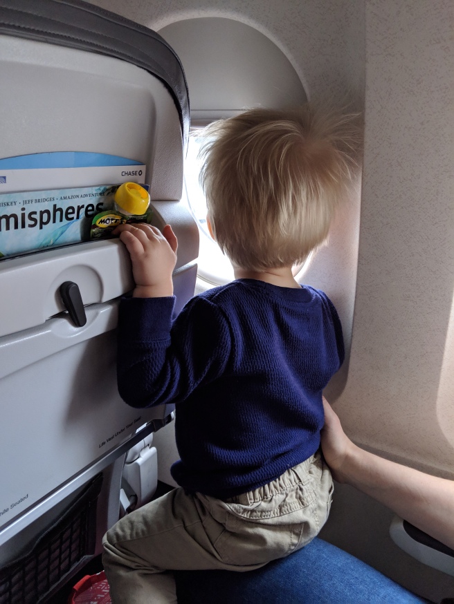 Little boy looking out plane window